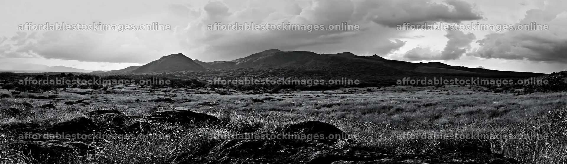 Kumamoto volcanic meadow with dark rocks and distant mountains – stock images 14762x4268