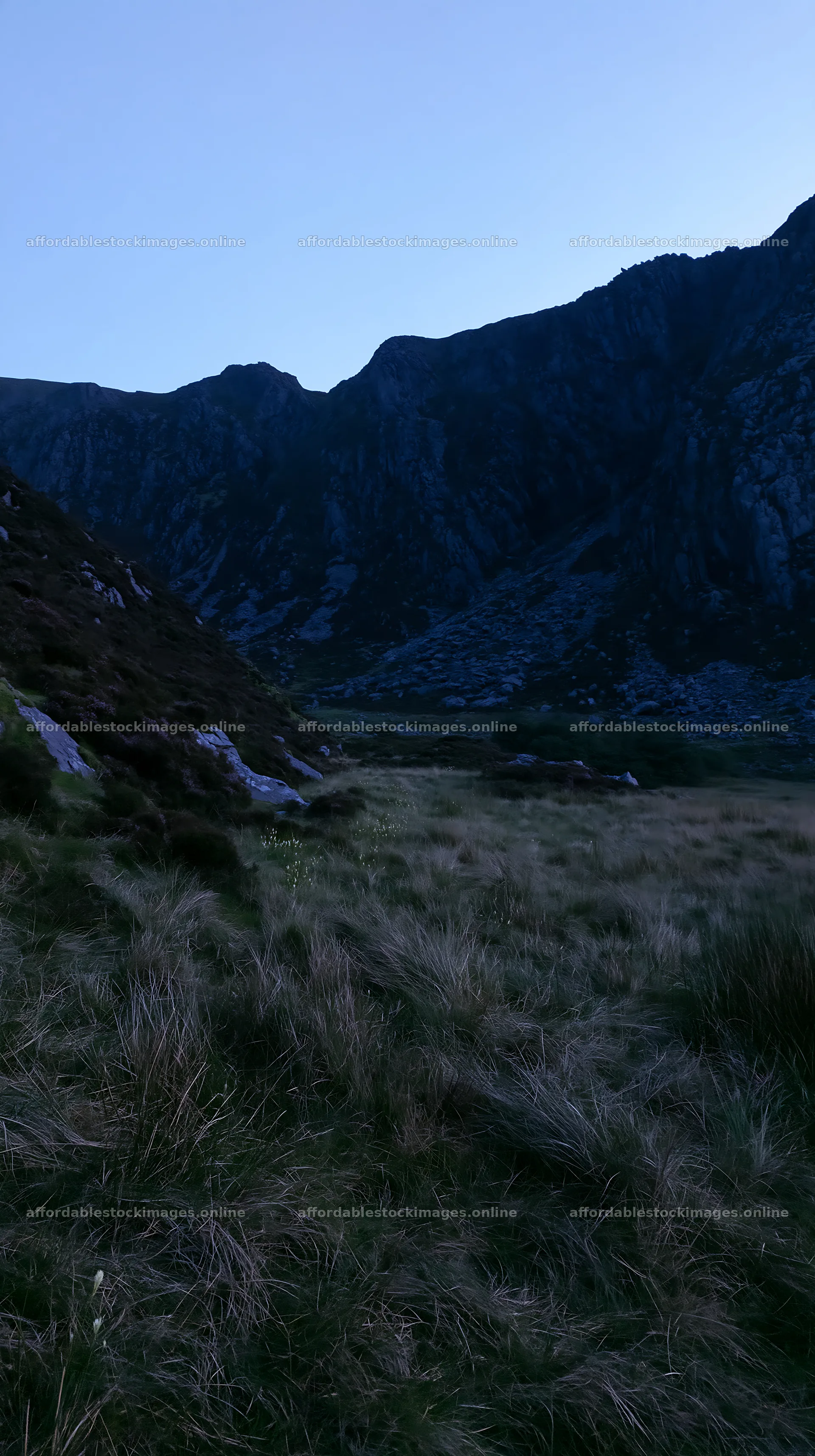 Meadow beneath crags at dusk – stock images 5938x10608