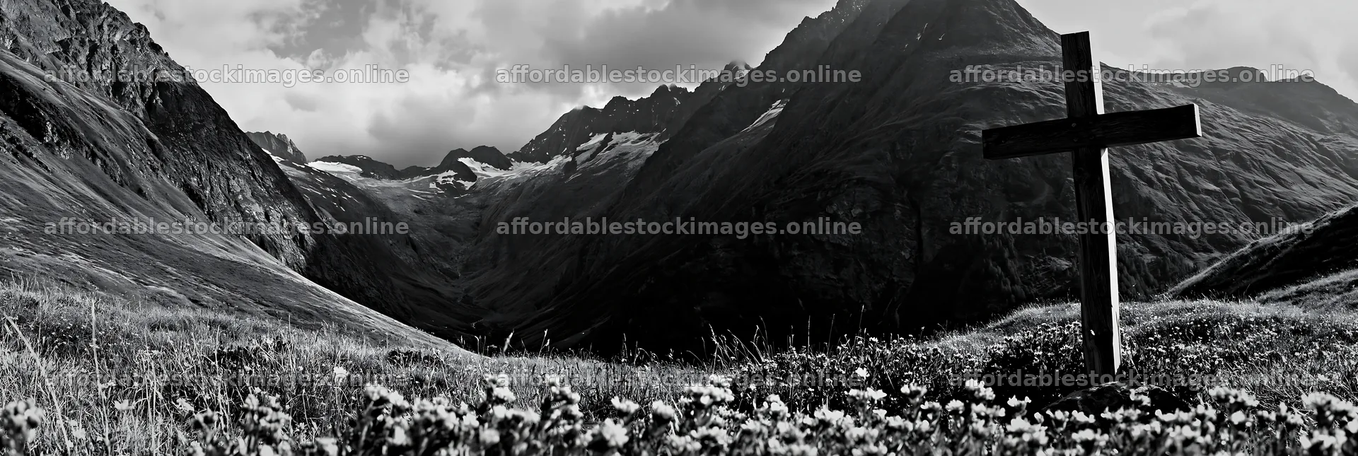 Wooden cross in a mountain meadow surrounded by flowers – stock images 13690x4602