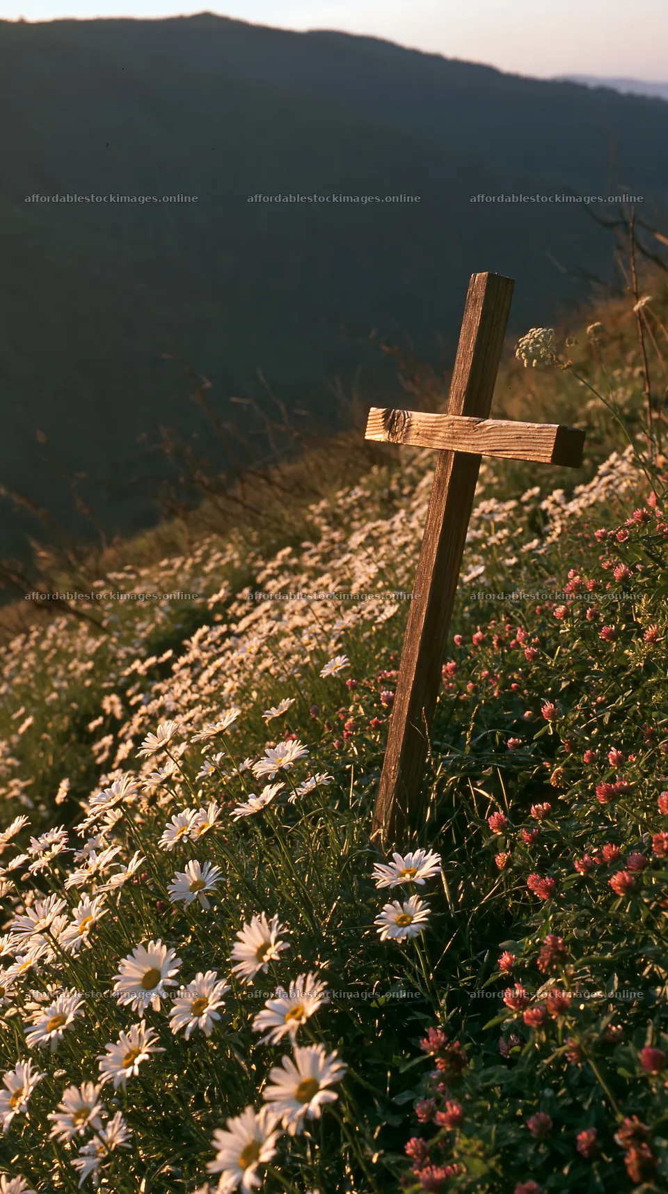 Christian cross above secluded mountain meadow – stock images 5938x10608