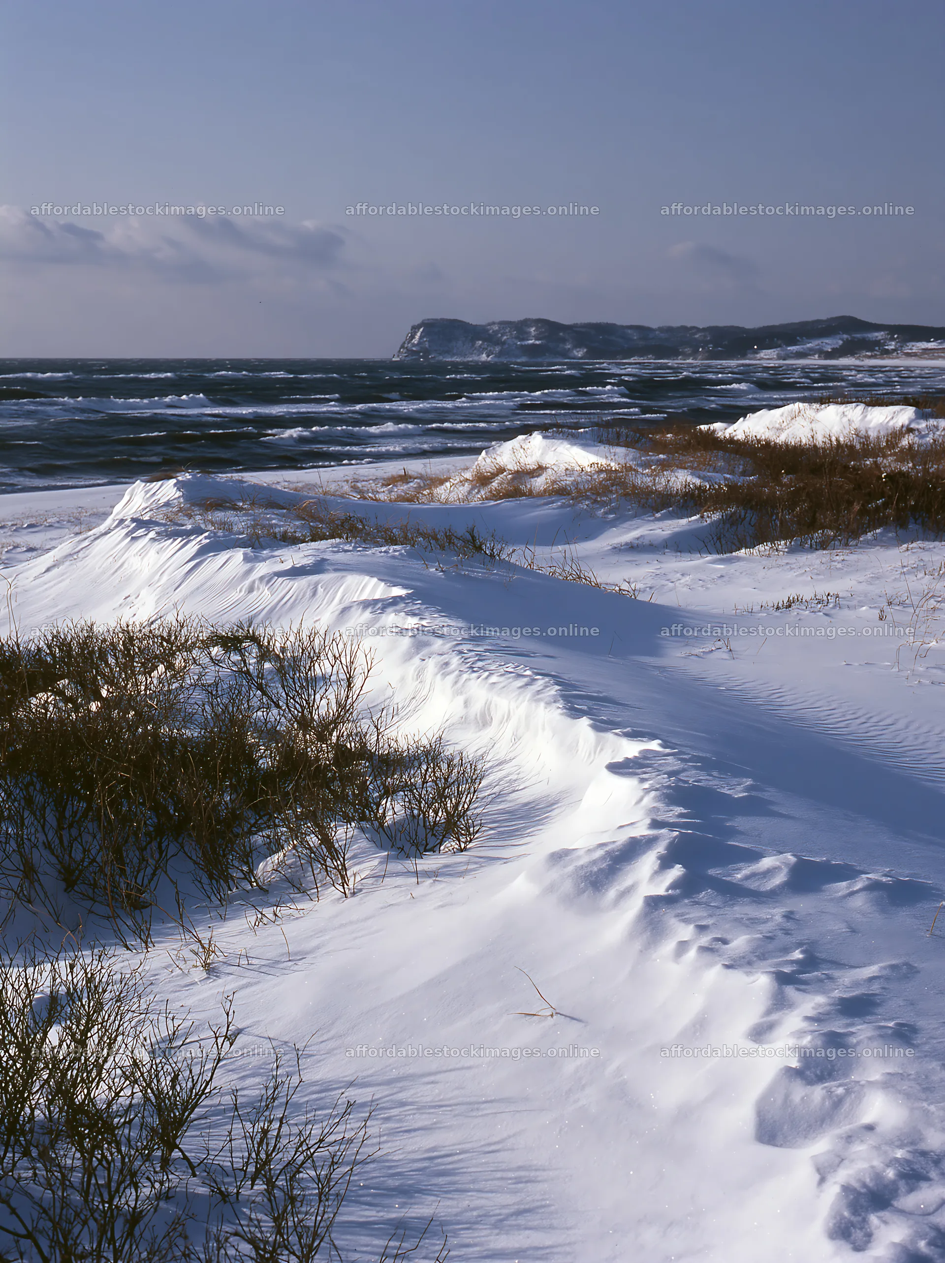 Snowy beach meadow under a clear sky with ocean waves – stock images 6866x9174