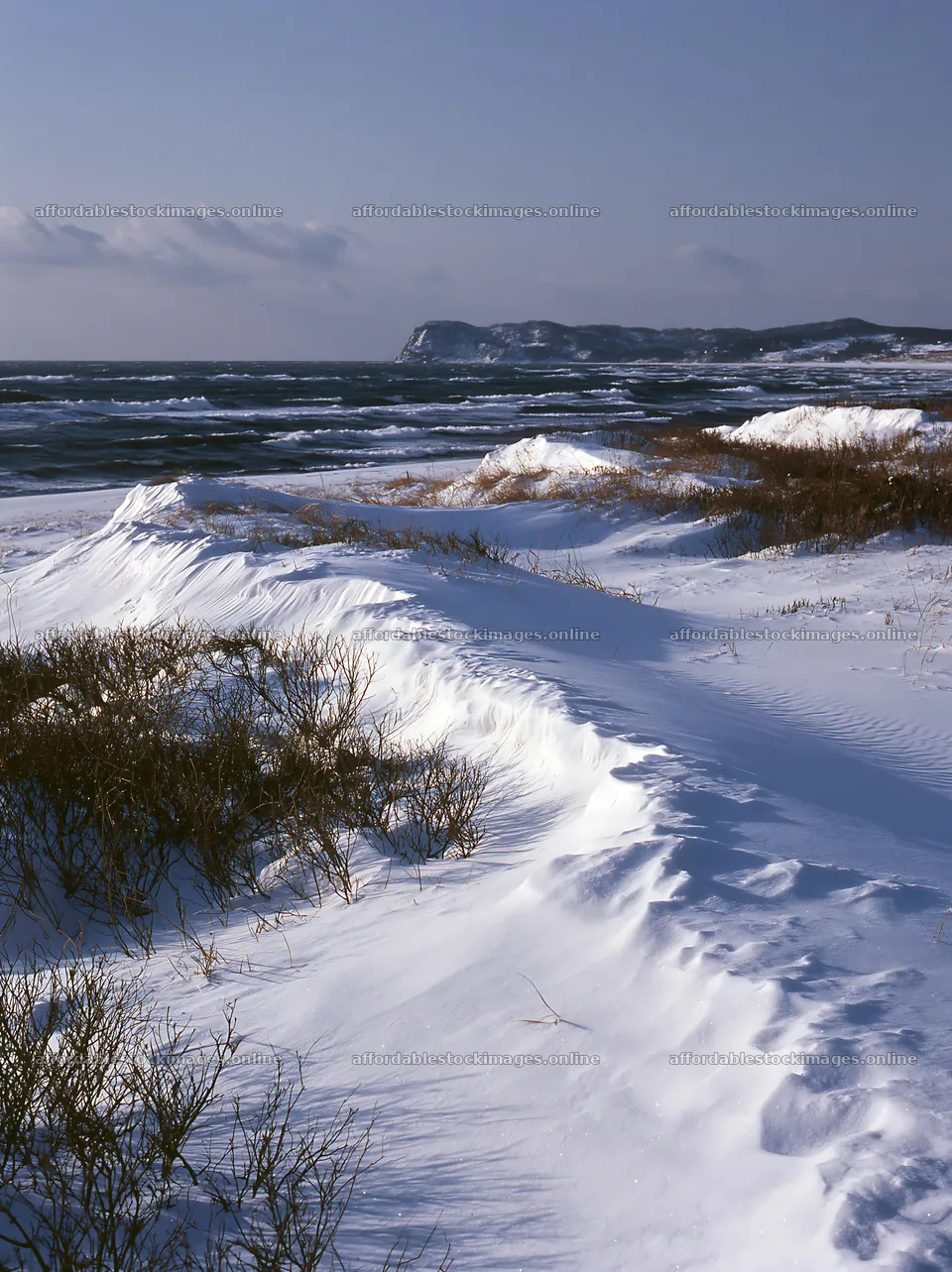 Snowy beach meadow under a clear sky with ocean waves – stock images 6866x9174