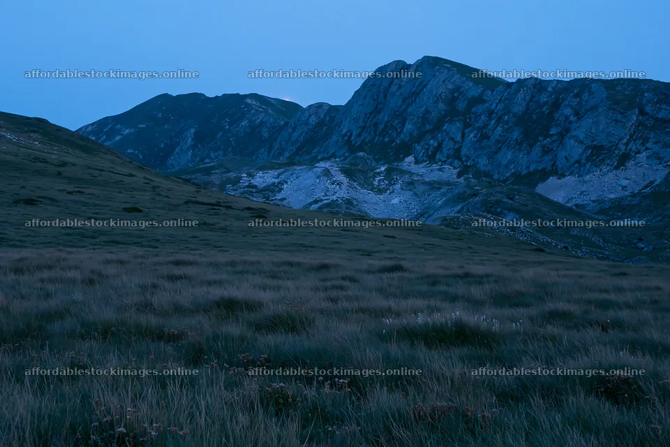 Moonrise over a meadow and mountains in twilight – stock images 9722x6480