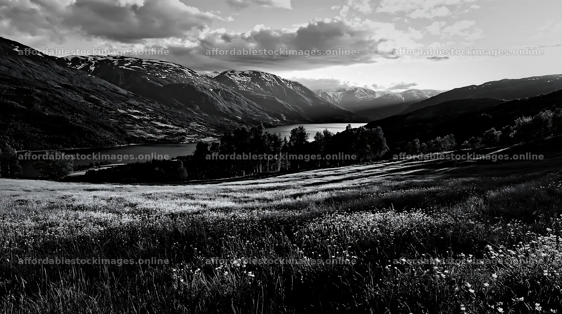 Rolling valley with lake and mountains under cloudy sky – stock images 10608x5938