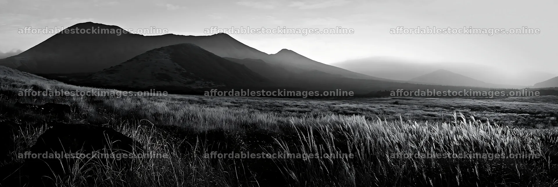 Kumamoto volcanic meadow dark rock foreground at sunrise – stock images 13690x4602