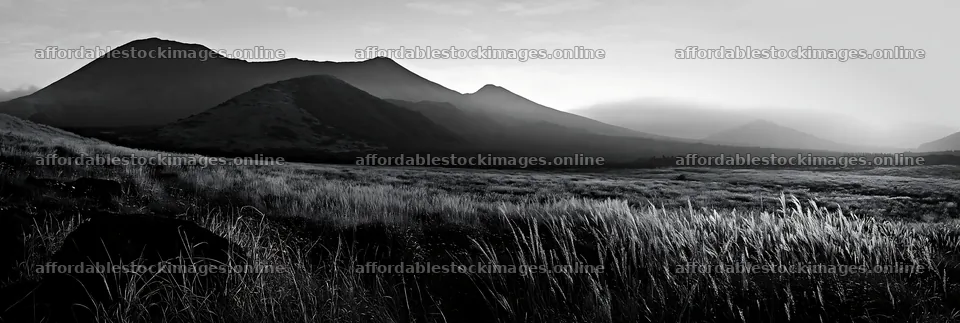Kumamoto volcanic meadow dark rock foreground at sunrise – stock images 13690x4602