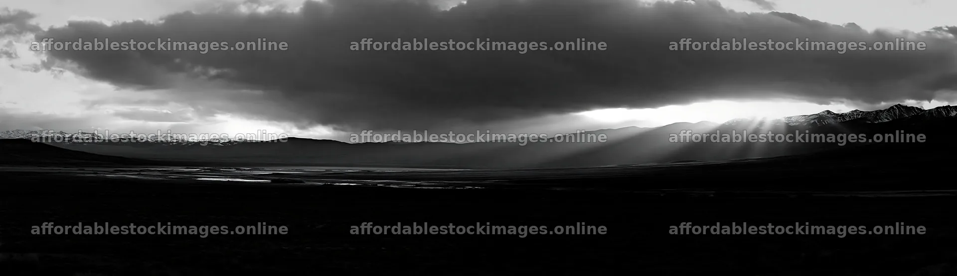 Sunrays shining through clouds over meadow and mountains – stock images 14762x4268