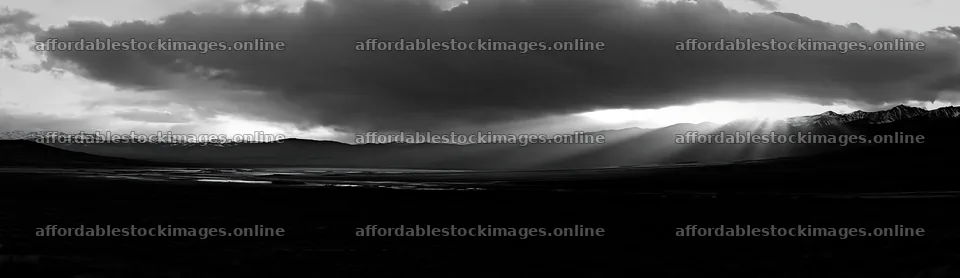 Sunrays shining through clouds over meadow and mountains – stock images 14762x4268